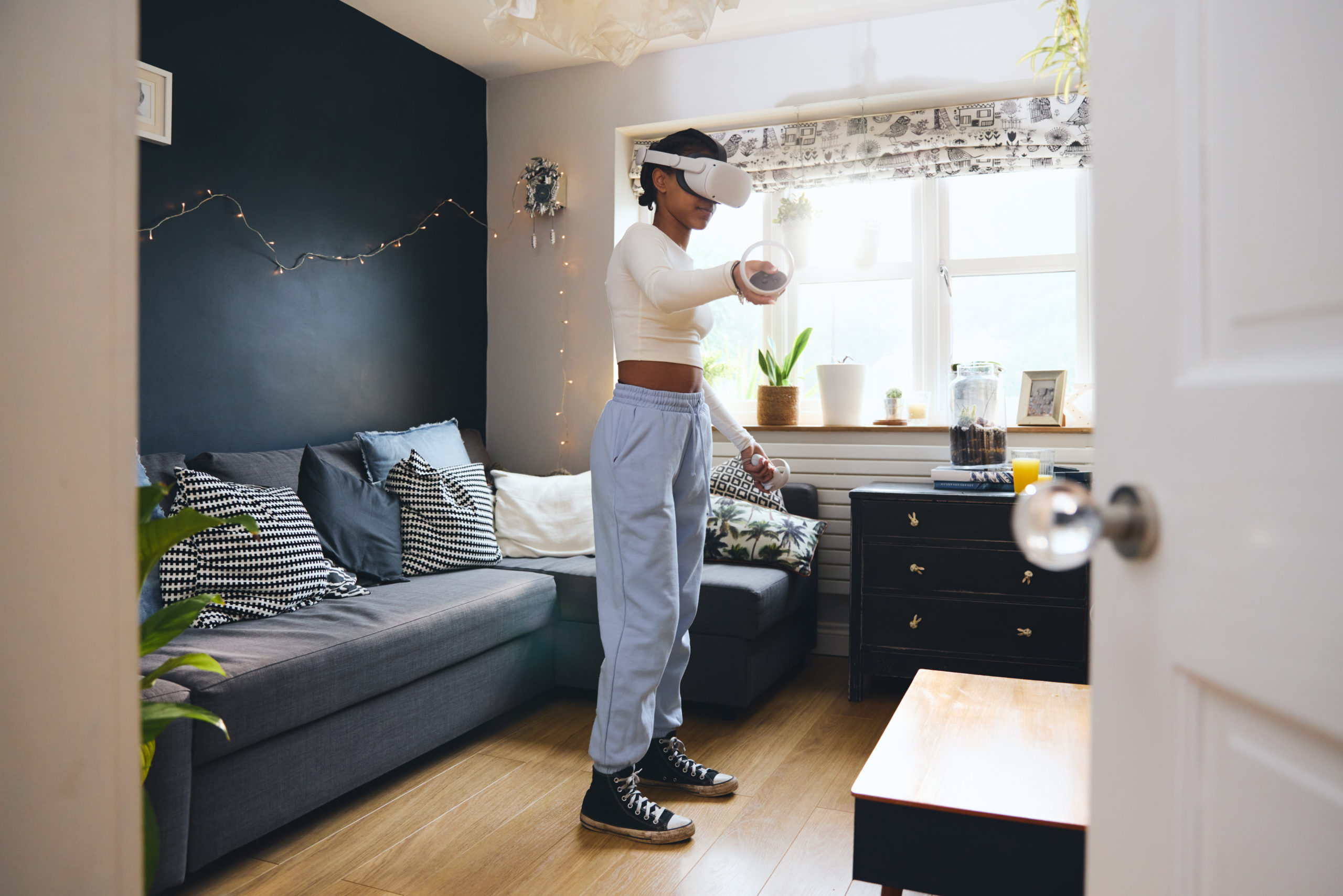 Teen girl wearing Virtual Reality headset at home
